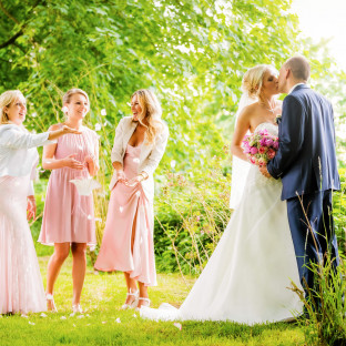 Hochzeitspaar mit Brautjungfern im Wald